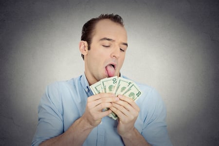Closeup portrait greedy banker, CEO boss, corporate employee, crazy guy, funny looking man obsessed, licking cash, money, dollars with tongue, isolated grey wall background. Face expression emotion